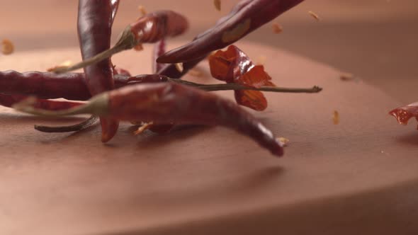 Chili peppers falling onto wooden surface in super slow motion.  Shot on Phantom Flex 4K high speed 