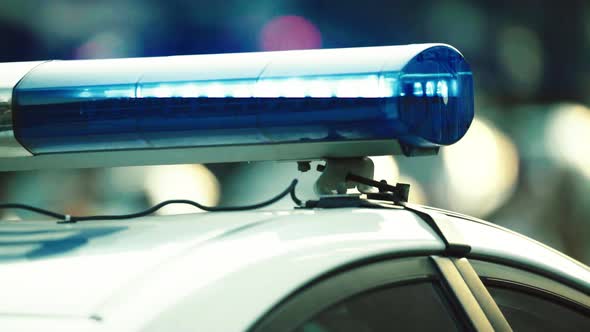 Flashing Flasher on the Roof of a Police Car. Blinker. Close-up. alt