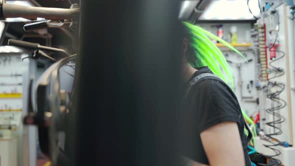 Woman Spinning Wheel of Bike in Garage