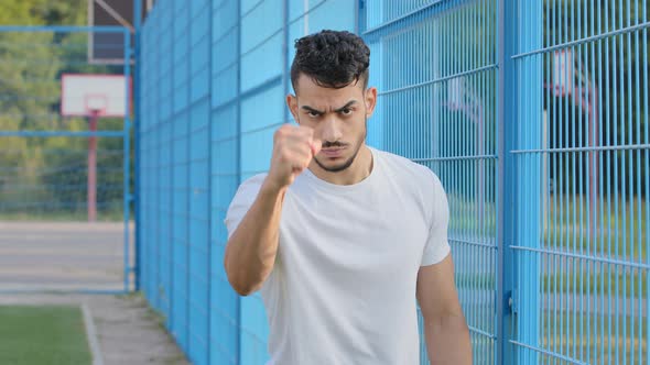 Angry Excited Football Fan Young Arabic Hispanic Male Athlete Waving Hand with Clenched Fist Middle alt