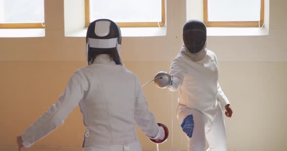 Fencer athletes during a fencing training in a gym alt
