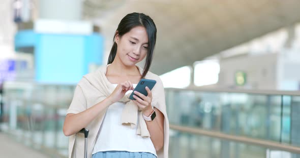 Young woman use of mobile phone in the airport alt
