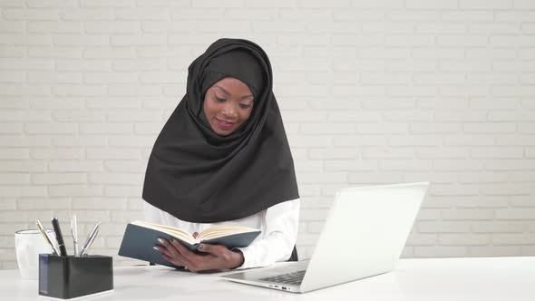 African Woman Turning Pages in Notebook alt