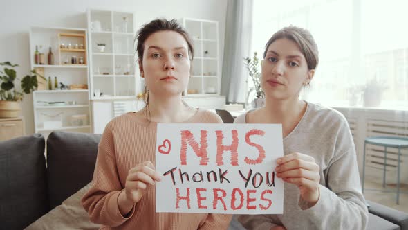 Two Young Women Saying Thanks to NHS at Camera while Staying at Home alt