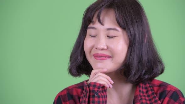 Face of Happy Asian Hipster Woman Thinking and Looking Up alt