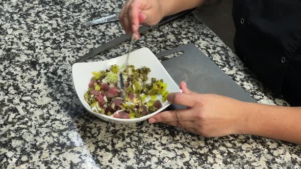 Close up of cooker mixing raw ingredients to prepare tartare alt