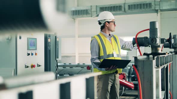 Wastewater Operator Inspecting a Sewage Cleaning System Using a Laptop alt