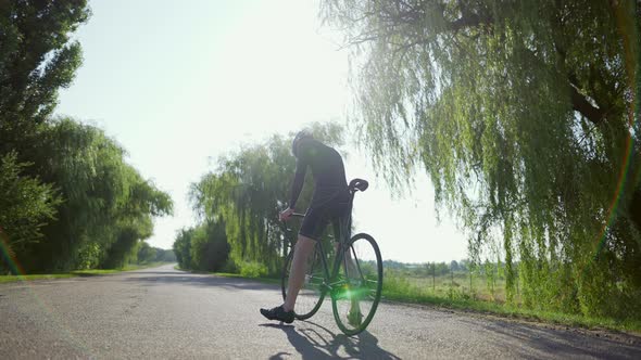 Confused Cyclist on the Empty Road Looking on Sides alt