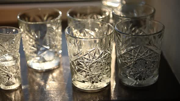 Beautiful Luxury Empty Crystal Glasses Stand on the Table Against the Background of the Sun Rays