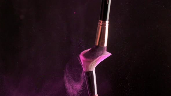 Two Makeup Brushes with Powder on a Dark Background Slow Motion