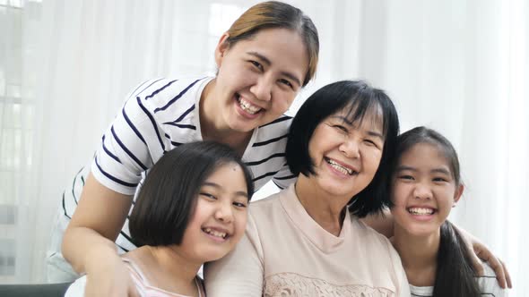 Slow motion of happy multi generation of  Asian family smiling together at home. alt