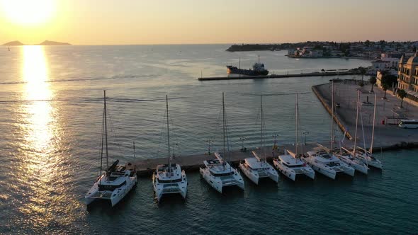 Catamaran and Sail Yachts Anchored at Bay on Deep Blue Sea Water on Sunrise alt