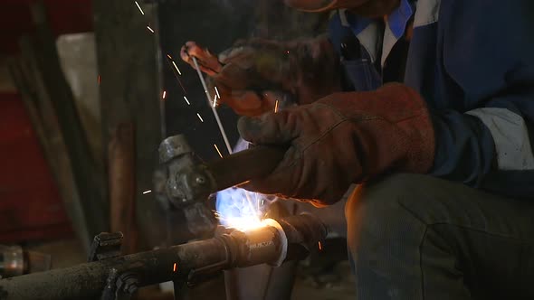 Close-up Master Welds Products. Worker Conducting Weld in Welding Workshop