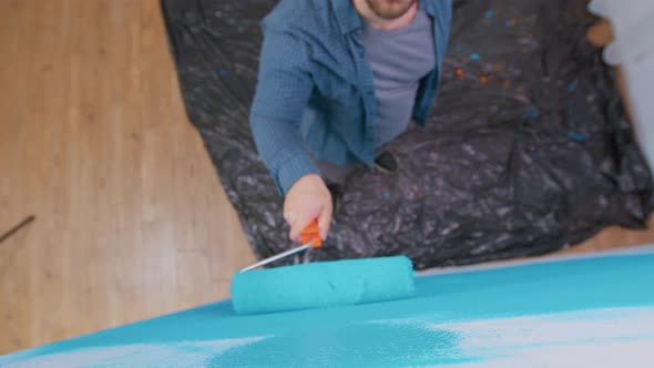 Top View of Man Painting Wall alt