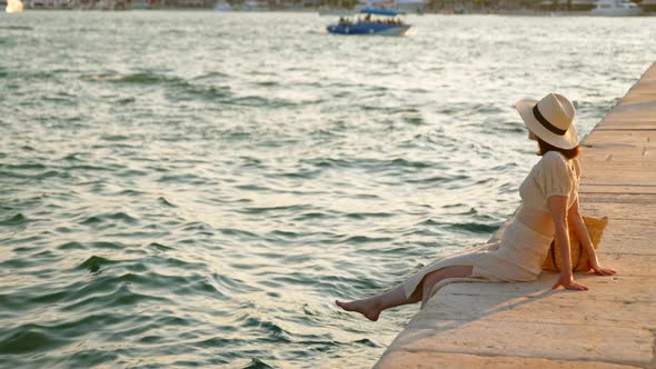 Happy woman with bare feet on the pier in summer. Split, Croatia alt