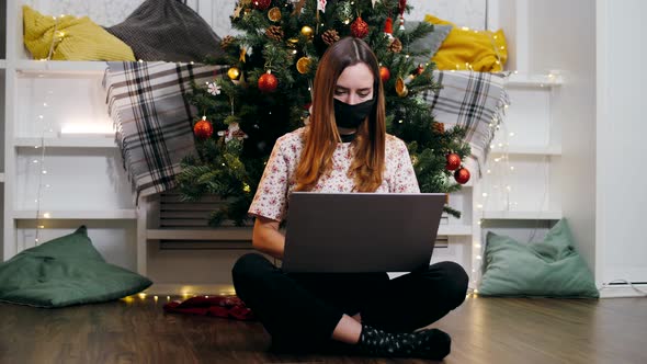 A young girl wearing a respiratory mask celebrates Christmas