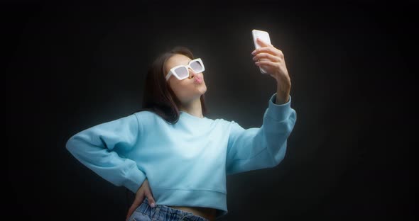 Young Asian Woman Makes Faces in Front of a Smartphone Taking Stupid Selfies