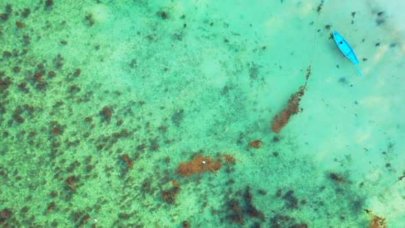 fishing boats floating over the fringing coral reef in the crystal clear turquoise sea water. drone alt