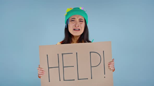 Woman holding cardboard with inscription help on it.