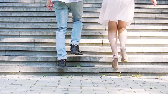 Easy-going young man and woman running upstairs in park, enjoying carefree life alt