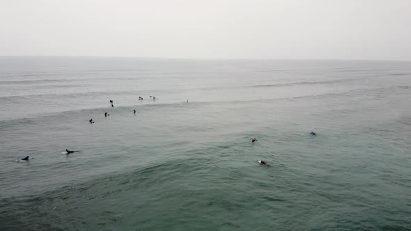 Aerial Circling View Over the Surfers in the Sea Paddling and Resting in Water Waiting for Waves alt