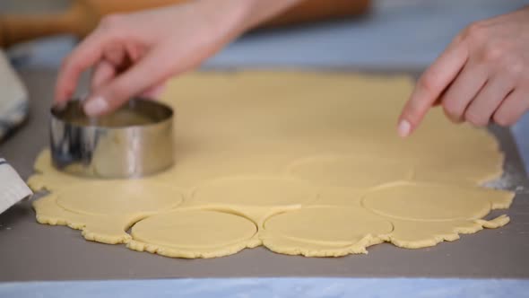 Young Woman is Cutting Circles of Dough