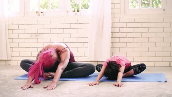 Asian mother and her kid daughter doing stretching exercise at home alt