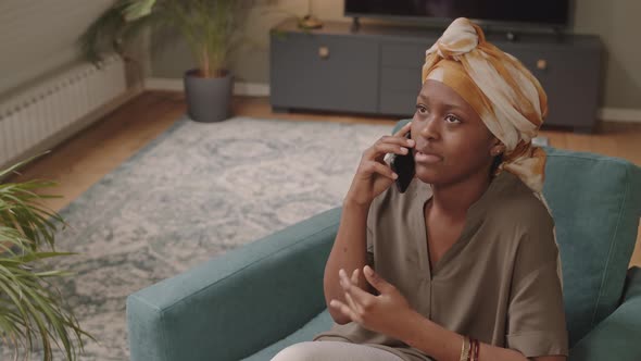 Cheerful Black Woman Talking on Cellphone Indoors alt