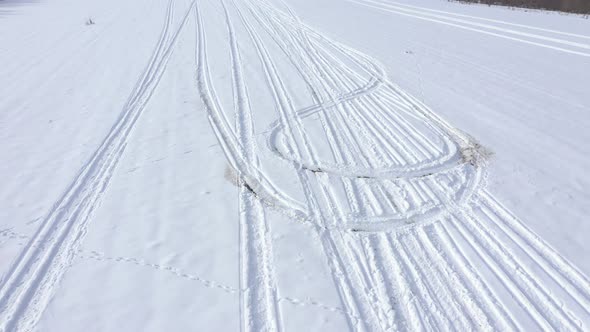 Marks in the snow from different vehicles 4K drone video alt