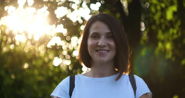 Evening Portrait of a Beautiful Young Woman in City Park alt