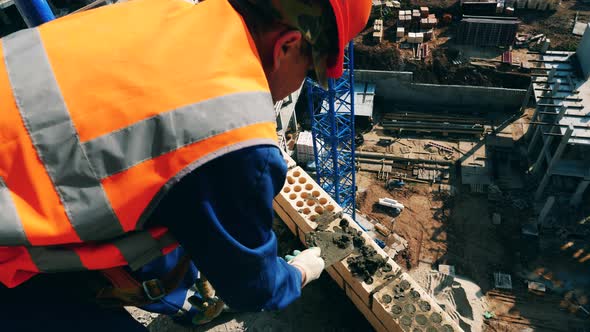 Construction Worker Is Casting Cement on the Building Wall alt