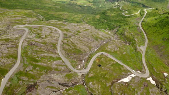 Aerial View Of Cars Driving Slowly On Winding Road By The Mountains In Norway From Eidsdal To Geiran alt