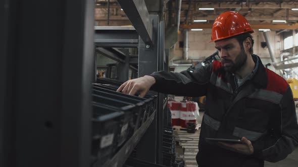 Man Checking Details at Factory alt