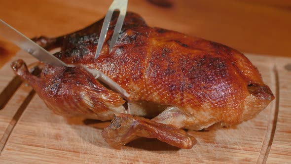 Delicious Young Roasted Duck Is Cut Off Along Leg With Sharp Knife