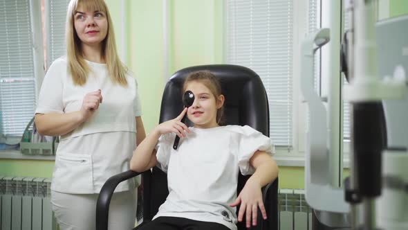an Ophthalmologist Diagnoses a Little Girl's Vision on a Sign Projector alt
