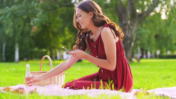 Happy Woman with Smartphone on Picnic at Park alt