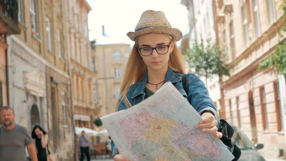 Young tourist woman exploring city map of lviv while traveling in Ukraine, vacation concept
