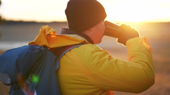 Hiker Young Tourist Enjoying Nature Drinking Hot Tea at Sunset alt