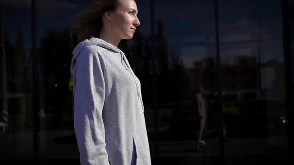 A Young Girl in a Hoodie and Jeans Travels Through the City Streets on a Gyrocopter alt