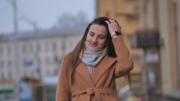 Portrait of a Posing Happy Girl in the City in Early Spring alt