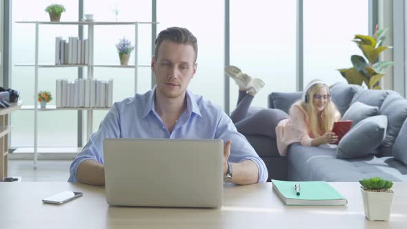 Smiling business blonde, white man person working from home on table with computer alt