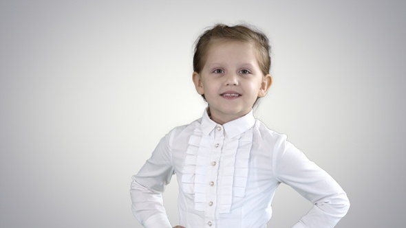 Cute little girl in white dress posing on camera on gradient alt