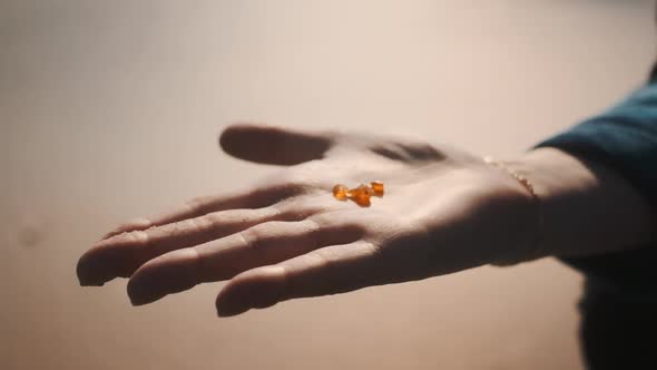Shot of Three Tiny and Beautiful Amber Sitting on Top of a Woman's Palm alt