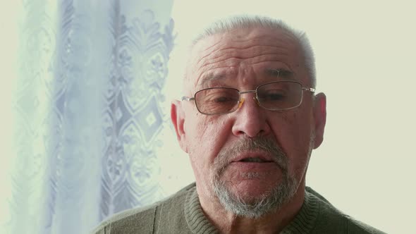 A Lonely and Worried Old Man Sitting in a Nursing Home alt