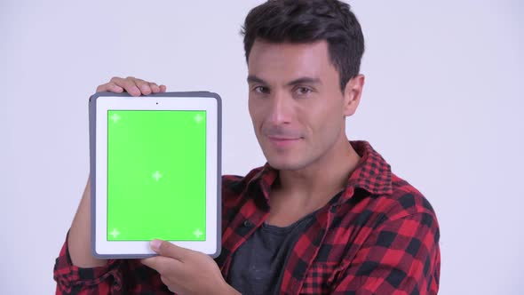 Face of Happy Young Hispanic Hipster Man Showing Digital Tablet alt