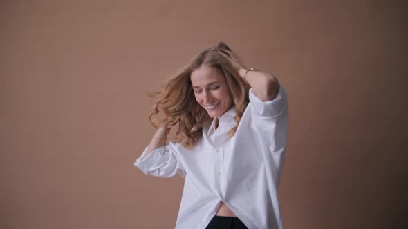 Elegant Professional Model in the White Shirt Posing to a Camera in the Studio alt