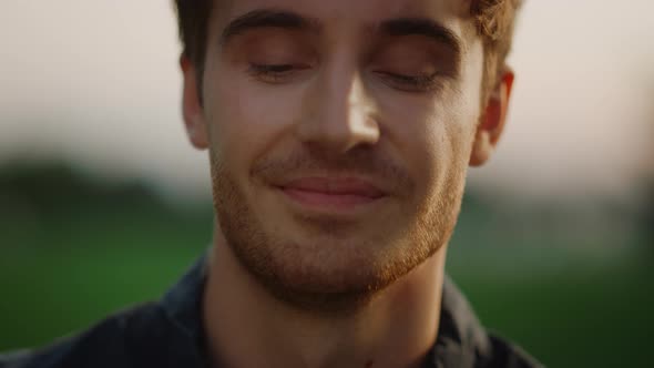 Handsome Man Looking at Camera Outdoors at Sunset. Cheerful Model Guy alt