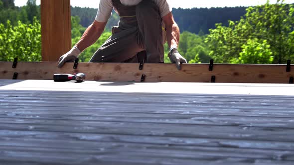 Installation of wooden terrace boards with trees on the background 4K