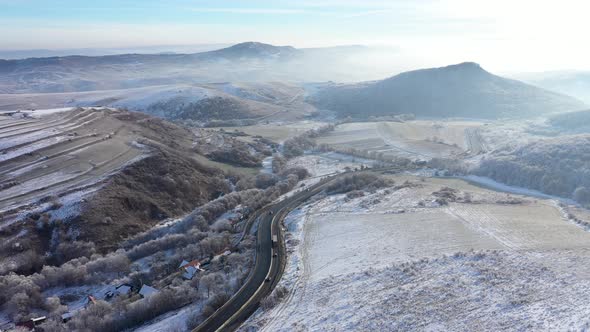 Aerial View of a Winding Road With Driving Cars in a Frosty Winter Sunny alt