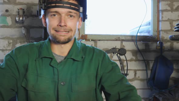 Young Repairman Taking Off Protective Eyewear and Showing Grimaces Into Camera alt